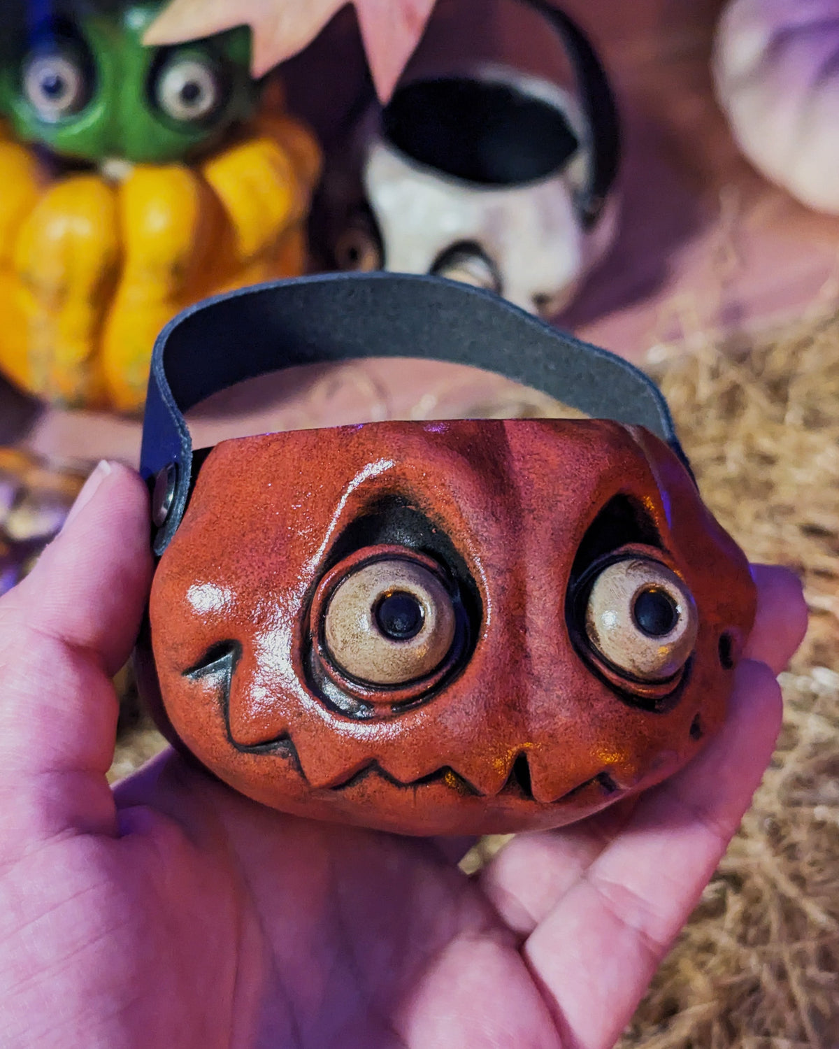 a small resin pumpkin being held