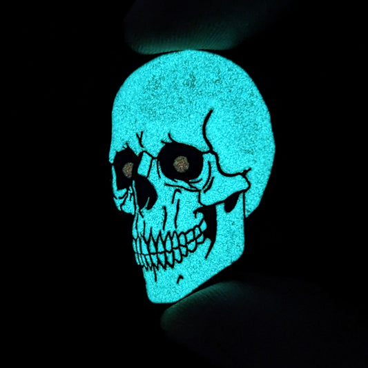 A human skull pin glowing in the dark